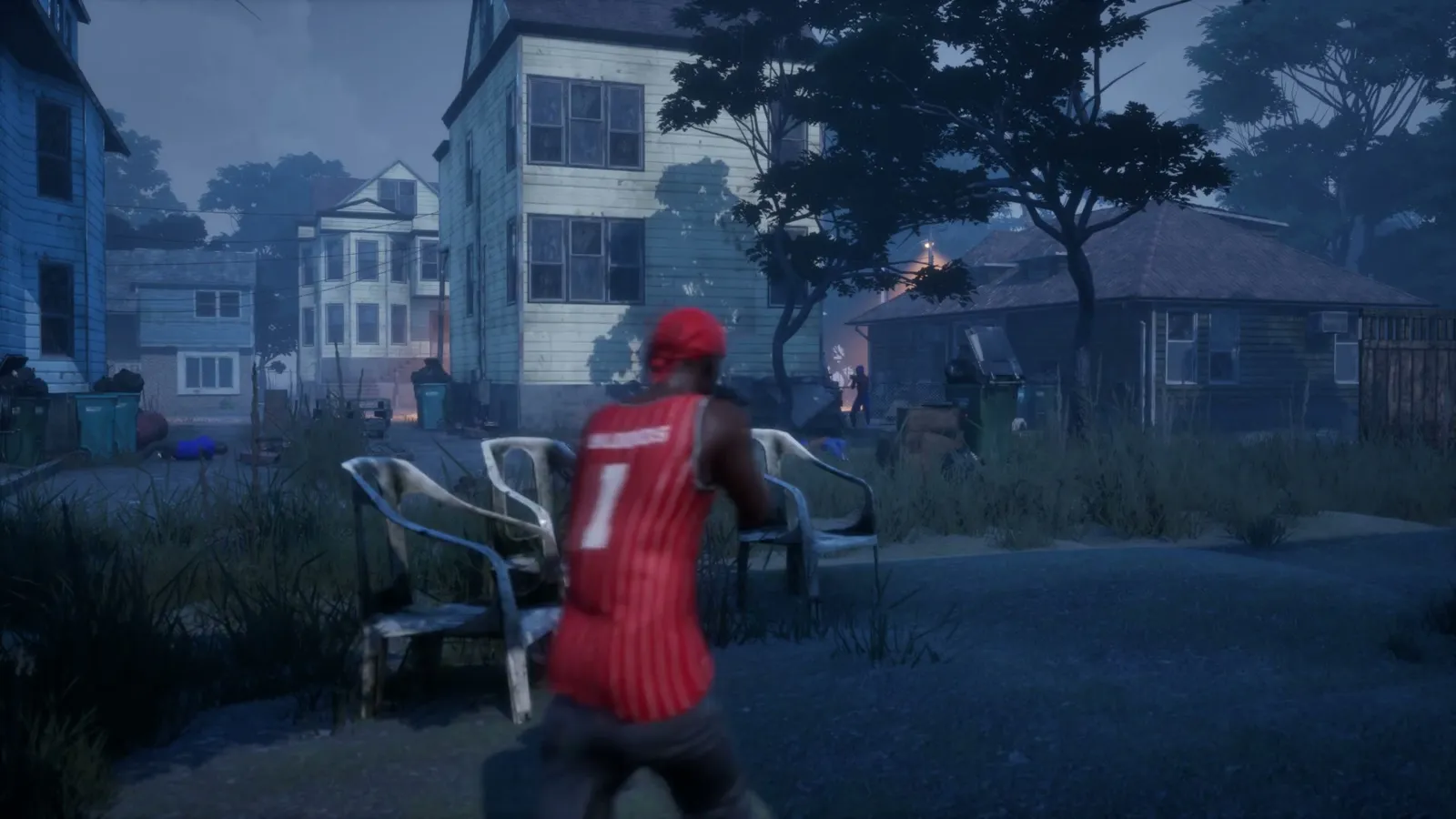 Player in a numbered red jersey running past a night street fence